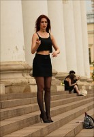 Девушка на улице в мини на каблуках